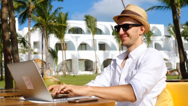 Şapkalı Dijital Göçebe Kumsaldaki Laptopta Uzaktan Çalışıyor.