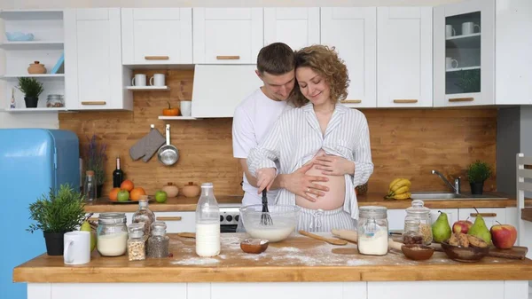 Glückliches schwangere Paar kocht gemeinsam in Küche — Stockfoto