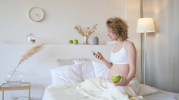 Concepto de Embarazo, Personas y Tecnología. Mujer embarazada usando Smartphone . — Foto de Stock