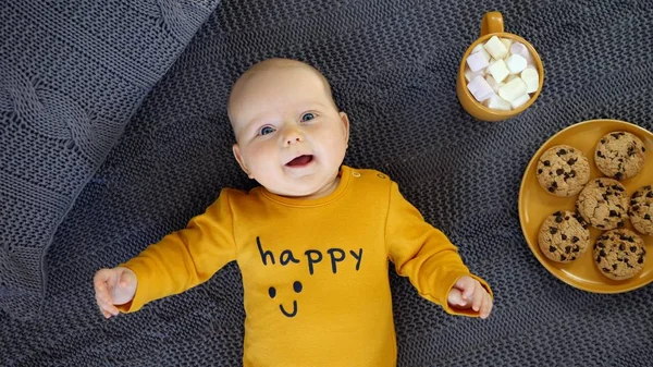 Kurabiye ve sıcak çikolatayla örgü ören neşeli kız..