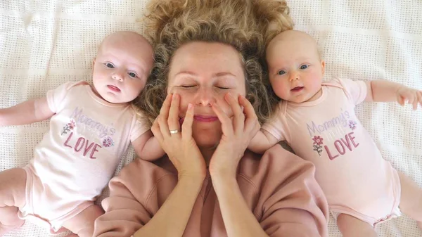 Mor blir galen med sin söta tvillingbebis. — Stockfoto