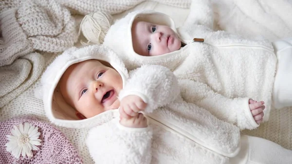 Happy Funny Baby Twins ležící na pletených přikrývky doma. — Stock fotografie