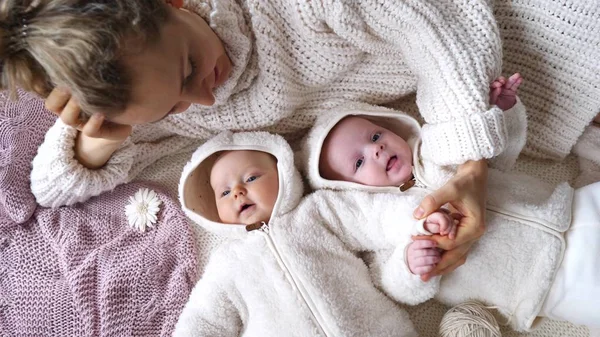 Mladá matka leží se svými malými dvojčaty — Stock fotografie