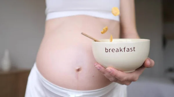 Femme enceinte prenant des céréales pour le petit déjeuner. Gros plan . — Photo