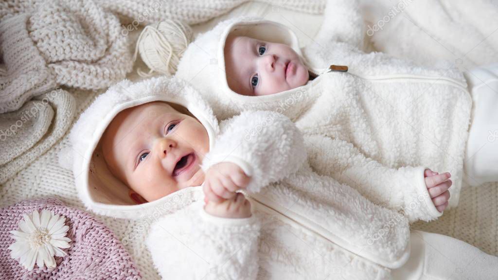 Happy Funny Baby Twins Lying On Knit Blankets At Home.