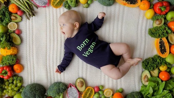 Sebze ve meyve ile çevrili vejetaryen bebek.