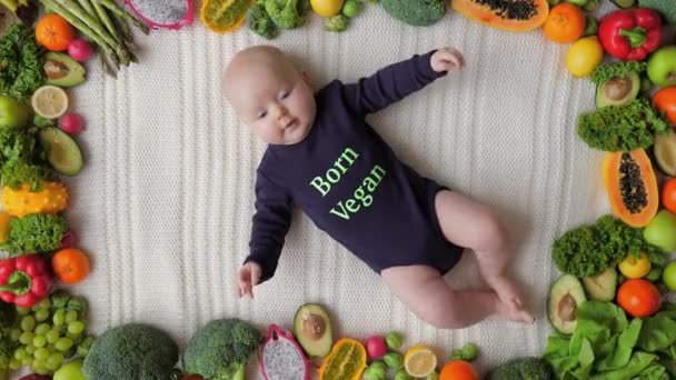 Bebê nascido Vegan. Menina bonito deitado em legumes e frutas . — Vídeo de Stock