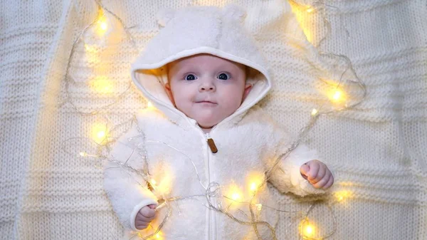 Bébé garçon bébé mignon dans des décorations de lumières scintillantes. Vue du dessus . — Photo