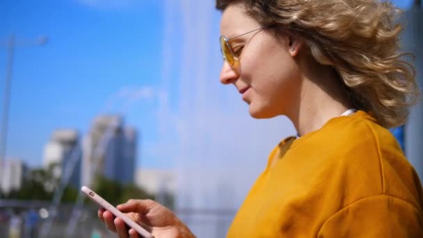 Rubia mujer rizada usando Smartphone en la ciudad . — Vídeos de Stock