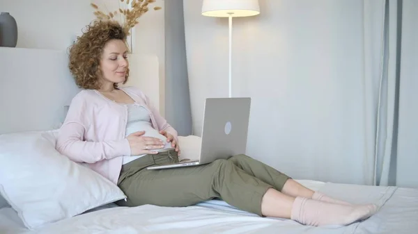 Mujer embarazada usando portátil acostado en la cama en casa — Foto de Stock