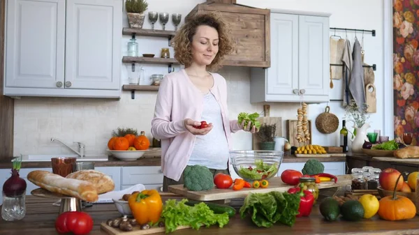 Беременная молодая женщина готовит здоровую пищу - овощной салат. Концепция диеты и питания. Здоровый образ жизни. Кулинария дома . — стоковое фото