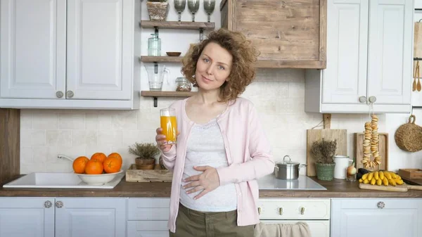 Schwangerschaft und gesunde Ernährung. Schwangere mit einem Glas frischem Orangensaft. — Stockfoto