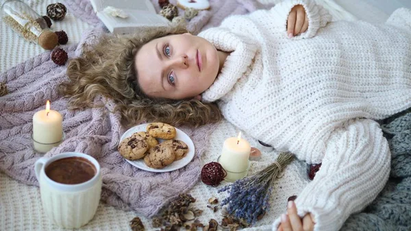 Молода жінка лежить на ліжку в'язаний светр . — стокове фото