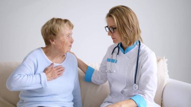 Doktor, şikayetleri olan yaşlı kadın hastasına teşhisi açıklıyor.