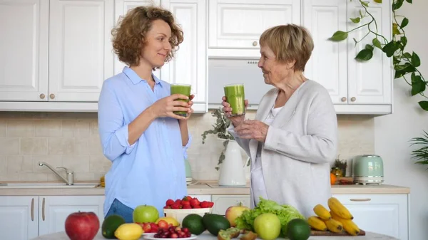 Unokák és nagymamák egészséges zöld turmixot isznak a konyhában. — Stock Fotó