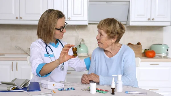 Médecin examinant le patient âgé et prescrivant des médicaments — Photo