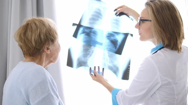 Здравоохранение, медицинская концепция. Доктор показывает рентген пожилому пациенту . — стоковое фото