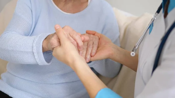 Main du médecin rassurant sa patiente âgée — Photo