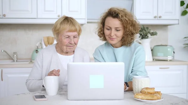 आजी आजीला लॅपटॉप संगणक कसे वापरावे हे शिकवते — स्टॉक फोटो, इमेज
