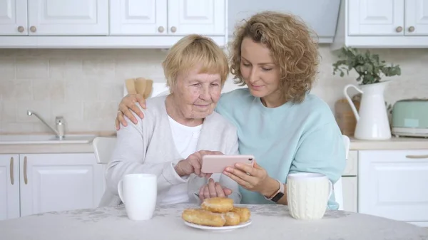परिवार, पीढ़ी, प्रौद्योगिकी और लोगों की अवधारणा स्मार्टफ़ोन के साथ दादी और दादी . — स्टॉक फ़ोटो, इमेज