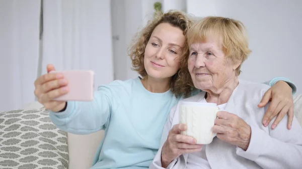 Primer plano retrato de feliz anciana feliz abuela tomando selfie con nieta — Foto de Stock