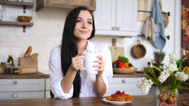 Bir fincan kahveli ya da evdeki mutfakta dinlenen genç bir kız..