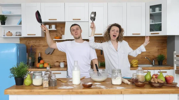 Engraçado jovem casal dançando na cozinha enquanto cozinha de manhã . — Fotografia de Stock