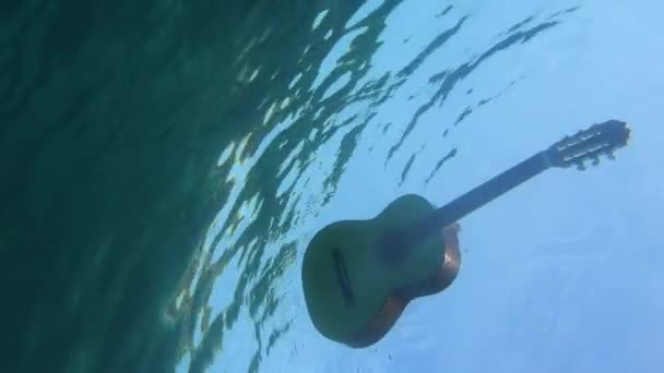 青い海の底から見た海に浮かぶスペイン語のギター — ストック動画
