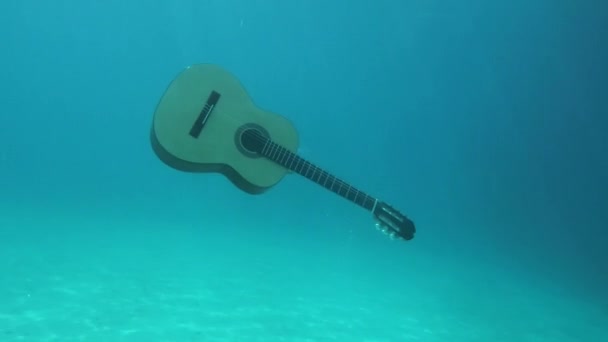 Spanische Gitarre Schwimmt Auf Die Oberfläche Des Blauen Meeres — Stockvideo