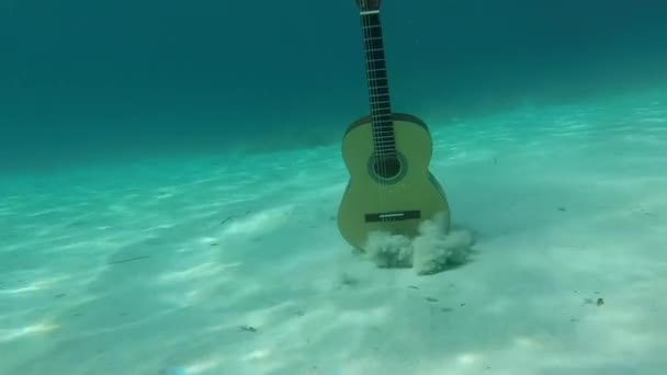 Guitarra Espanhola Sob Mar Azul Caindo Fundo Arenoso — Vídeo de Stock