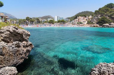 Mar Kampı, Mayorka 'da insanlarla dolu bir sahil ve deniz manzarası.