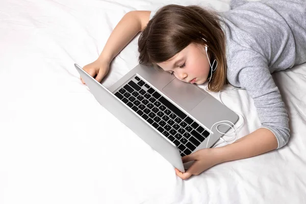 Uzaktan öğrenmekten yorgun bir çocuk. Çocuklar ve gençler için evde eğitime geçiş. Evde eğitim ve evde çocuklara ders veren ebeveynler. Karantina sırasında çocuklar için çevrimiçi eğitim.
