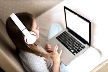 Kız internete giriyor. Liseli kız çevrimiçi çalışıyor. Evde eğitim. Bilgisayarın önünde yorgun bir çocuk. Mesafe ve çevrimiçi eğitim ve çocuklar için uzaktan öğrenme. Karantinada evde eğitim.