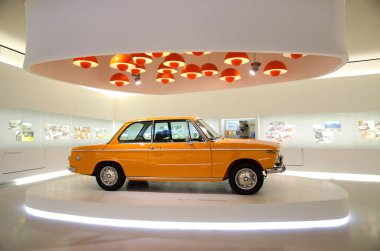 İhtişamlı salonda turuncu sedan. Kırmızı lamba yerde.