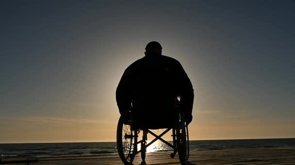 Инвалид Инвалидной Коляске Двигается Сторону Моря Силуэт Замедленной Съемки — стоковое видео
