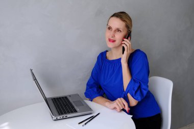 Bilgisayara gülümseyen ve işte konuşan bir kadın.