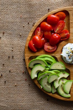 Kavram tasarımı için kiraz domatesleri ve avokado kırsalına yakın çekim. Sağlıklı beslenme kavramı. Taze meyve ve sebzeler. Taze ve yaz ürünleri. Yemek takımı. Doğal ahşap zemin.