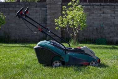Çim biçme makinesi olan bir adam çimleri biçer. Arka bahçeyle ilgileniyorum. Pürüzsüz, güzel yeşil çimenler. Bahçe işleri /
