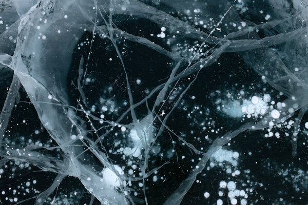 Close Up photo of ice cracks for wallpaper design. Grunge texture of ice. Winter landscape. Nature background. Blue color background. Frozen water. Ice clear surface