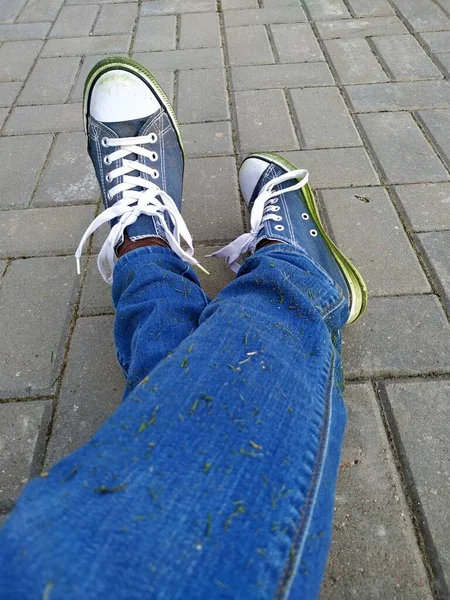 Denim sneakers gekleurd met groen gras van een lange wandeling — Stockfoto