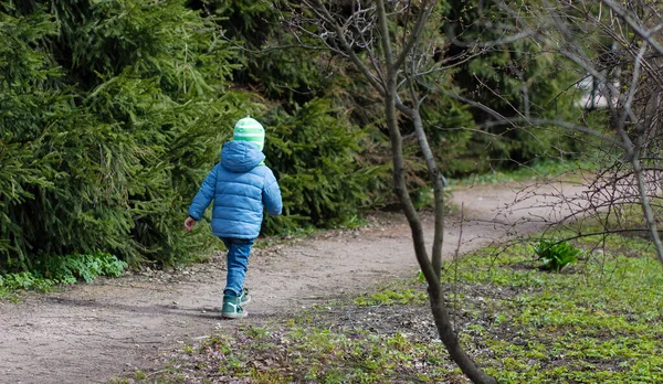 Sıradan giyinmiş bir çocuk yolda yürüyor.