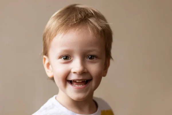 Kameraya gülümseyen genç bir çocuk.