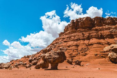 Mavi gökyüzü ve önünde kayaları olan büyük bir dağ.