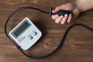 Ahşap arka plan üzerinde basınç ölçer ile eller