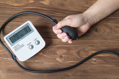 Ahşap arka plan üzerinde basınç ölçer ile eller. Yakın çekim