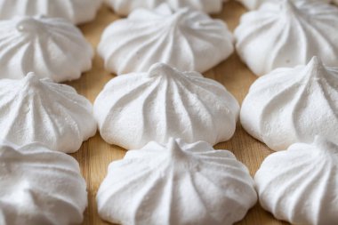 Ahşap arka plan üzerinde taze mini meringues.