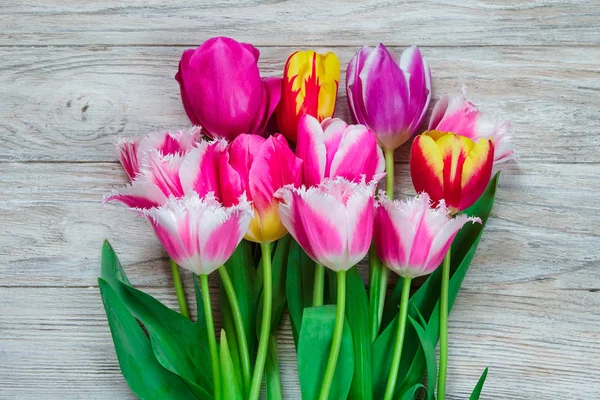 Ramo de hermosos tulipanes sobre un fondo de madera — Foto de Stock