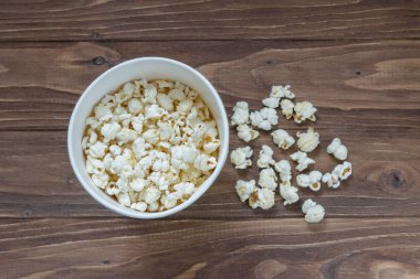 Kahverengi ahşap arka plan üzerinde lezzetli patlamış mısır