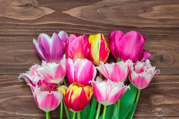 Ramo de hermosos tulipanes sobre un fondo de madera marrón. De cerca. — Foto de Stock