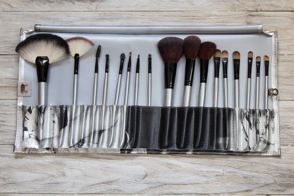 Set of cosmetic brushes on a wooden background. Top view